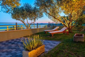 An outdoor seating area with lounge chairs and a view of the sea. - Mobile Home Pecten 01 (Pakostane)