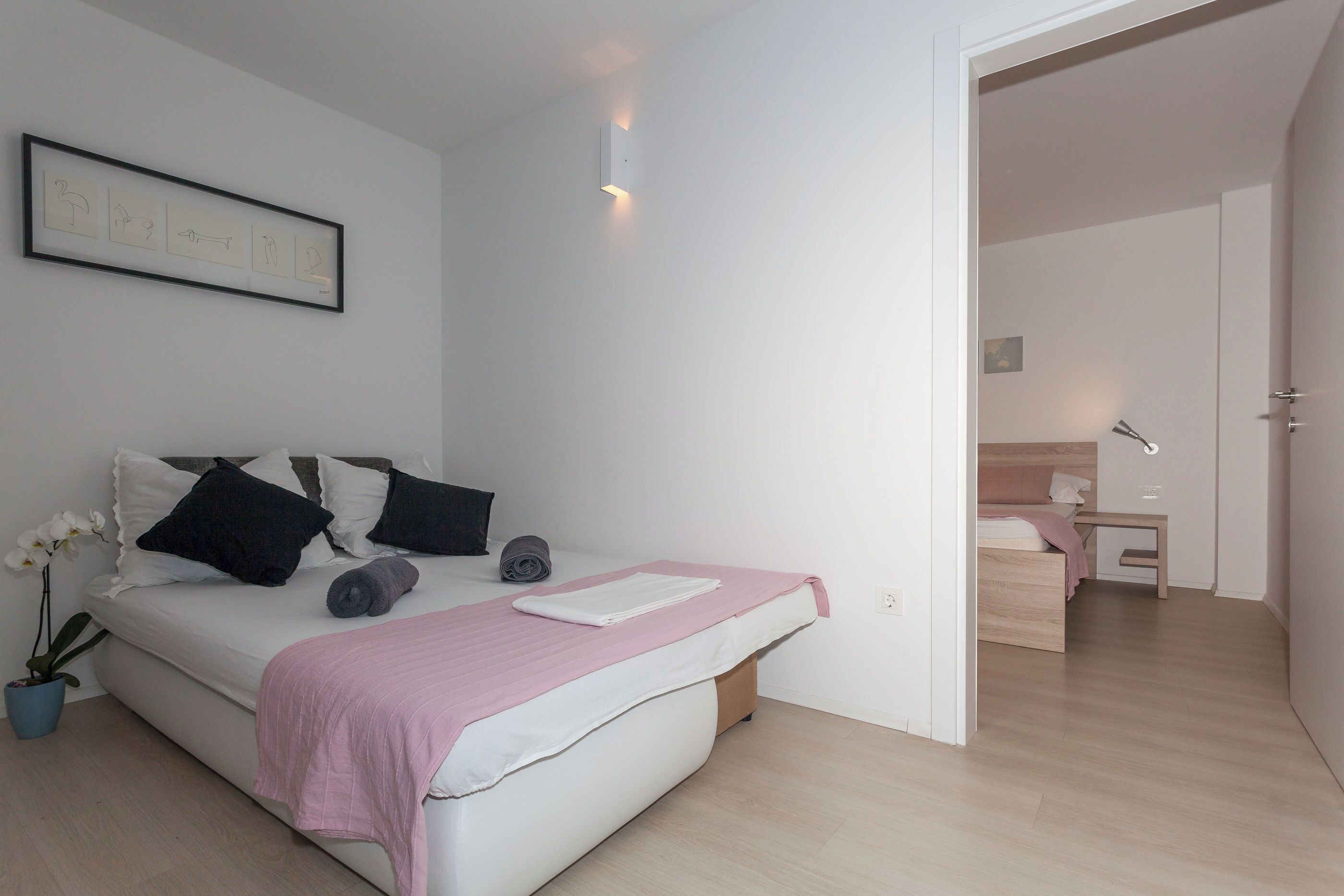 Una camera da letto moderna con un letto, un comodino e una piccola scrivania.