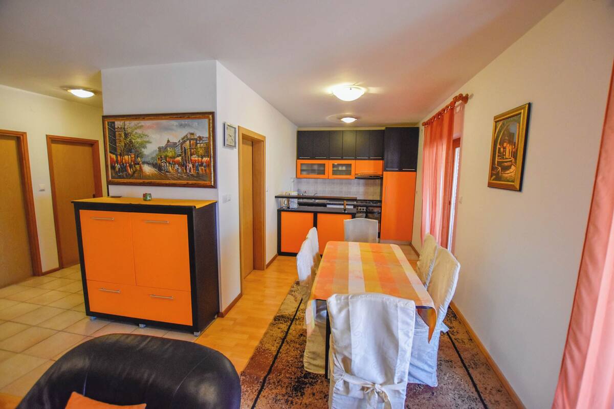 Un espace de vie compact comprenant un coin repas, une cuisine et un petit coin salon.