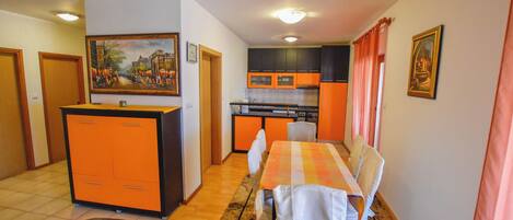 A compact living space with a dining area, kitchen, and a small seating area.
