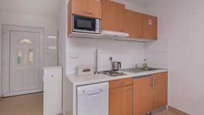 Cozinha compacta com micro-ondas, torradeira, pia e lava-louças.