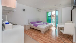 Quarto moderno com cama, mesa de cabeceira e escrivaninha com cadeira.