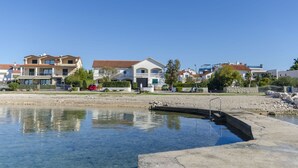 Zona residencial con casas, piscina y playa.