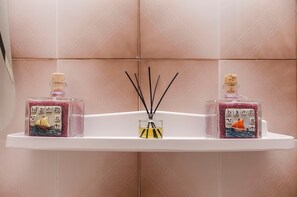 A bathroom shelf with two bottles of liquid soap and a small bottle of essential oil. - Apartment Robyn on the Beach (Srima)