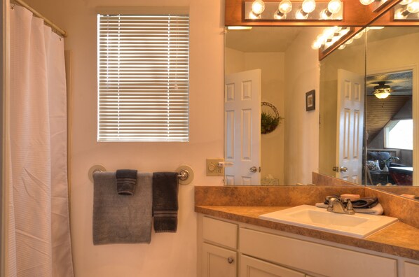 A bathroom with a sink, mirror, towel rack, and window with blinds. - 5-STAR HOME WITH LONG RANGE VIEW, PAVED TO THE DOOR ACCOMODATES 5 LARGE VEHICLES (Franklin)