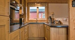 A wooden kitchen with a window, a sink, and cabinets. - Skye View. Felmoor Park (Morpeth)