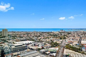 A cityscape with a view of the ocean, buildings, and roads.