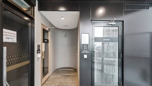 A modern hotel entrance with a glass door labeled 'STEAM,' a sign indicating 'MAX TEMP 44°C,' and a 'Doors Must Be Kept Closed at All Times' sign. - Sierra - Resort Living * Gym Sauna Pool WiFi (Southbank)