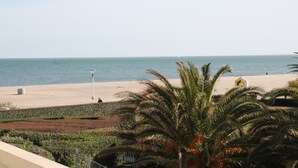 Uitzicht op een strand met palmbomen en een heldere lucht.