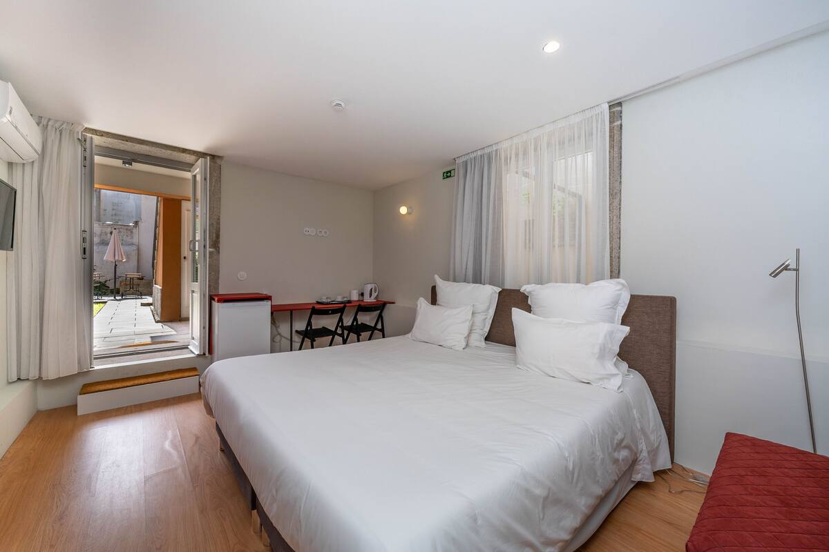Una habitación de hotel con una cama, un escritorio y una silla.