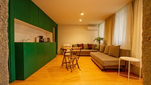 Una sala de estar moderna con un sofá, una mesita y una pared de acento verde.