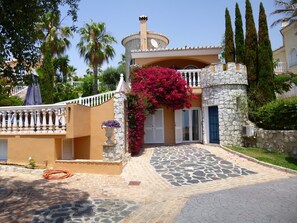 Une villa de style méditerranéen avec une façade en pierre, une cour intérieure et une fontaine.