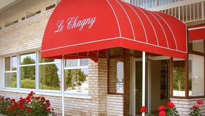 A building with a red awning labeled "Le Chagny" and a brick facade. - Le Chagny Hotel (Chagny)