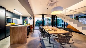 Contemporary kitchen and dining area with central island, sink, and dining table for six.
