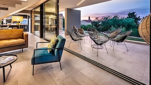 Relax in this serene outdoor seating area with a mix of seating options and a view of the surrounding trees.