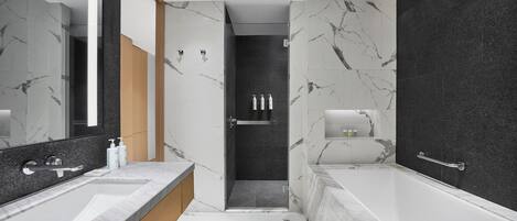 A modern bathroom with a large mirror, a bathtub, and a shower area.