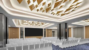A modern conference room with rows of white chairs, a large screen, and a patterned ceiling.