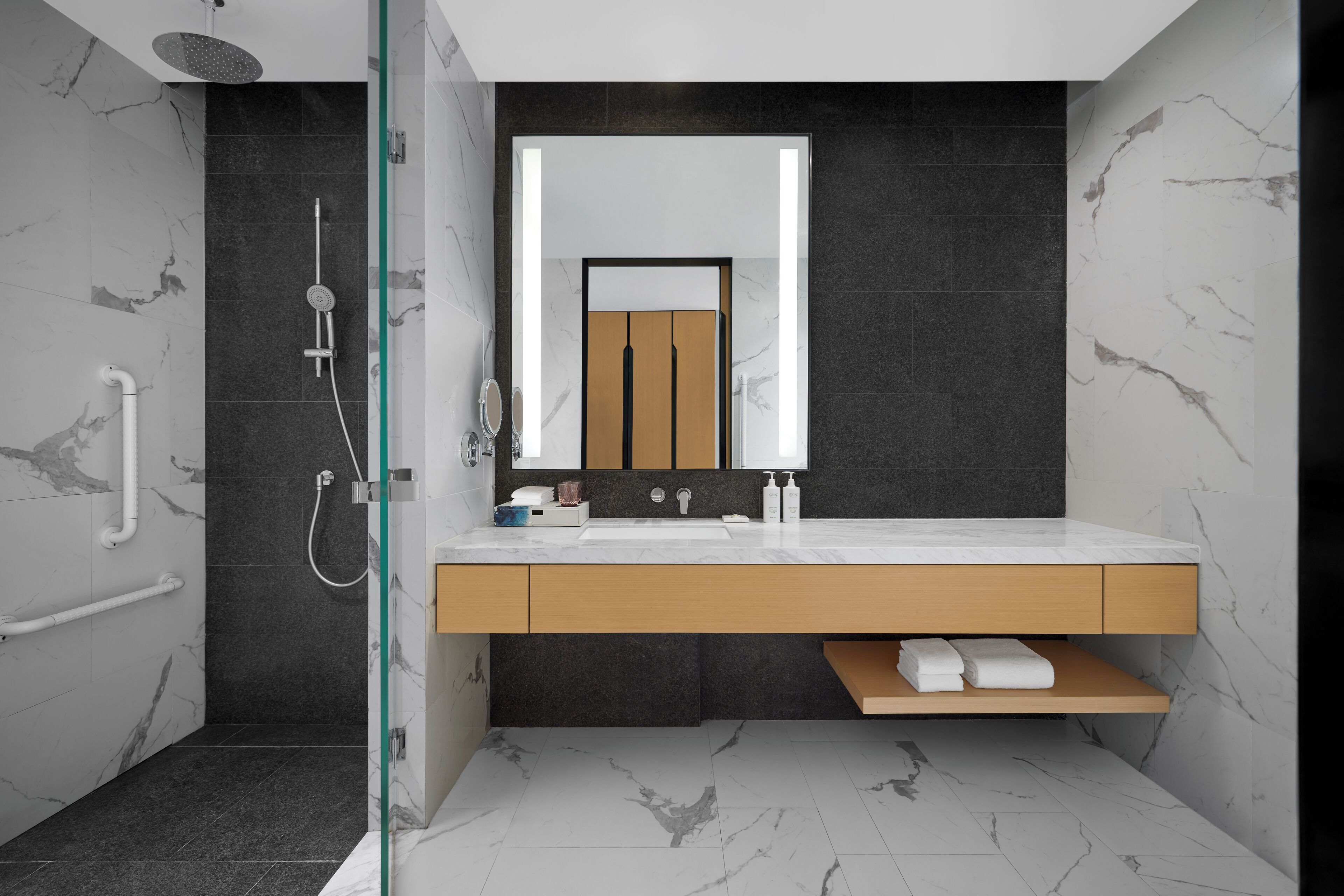Ein modernes Badezimmer mit Dusche, Waschbecken und Spiegel.