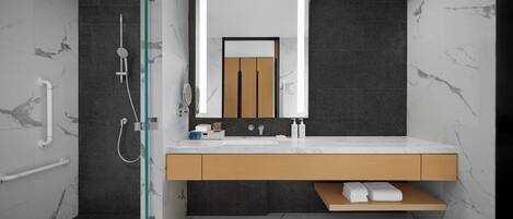 A modern bathroom with a shower, a sink, and a mirror.