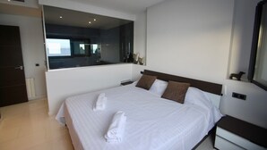 A modern hotel room with a large bed, a bedside table, a nightstand, a mirror, and a view of the room's interior. - Athena beauty in Altea (Altea)