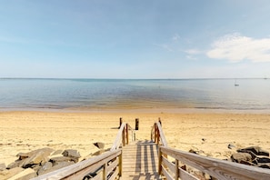 Walk along the weathered boardwalk to a serene beach with calm waters.