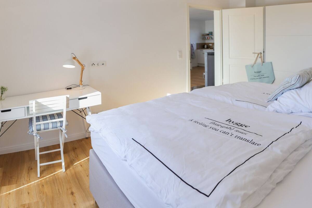 Um quarto com uma cama, uma escrivaninha e um guarda-roupa.