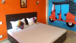A hotel room with a bed, orange walls, a mural of a red scooter, and a framed picture on the wall. - EL PROFESOR MCLEODGANJ (Dharamshala)