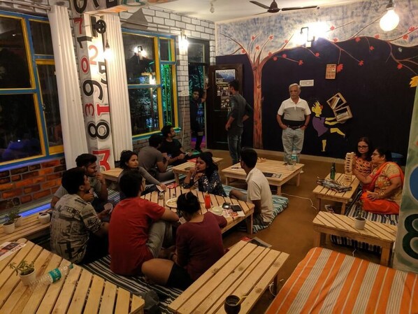 Un restaurante con mesas y bancos de madera, un muro de ladrillo y un mural de un árbol.