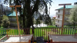 A children's play area with a colorful floor, two swings, and a small table. - EL PROFESOR MCLEODGANJ (Dharamshala)