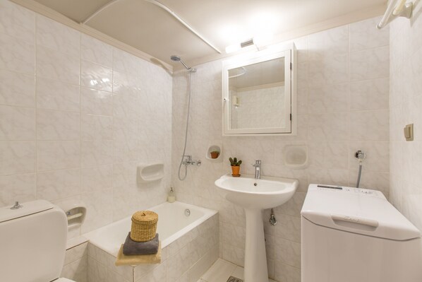 A bathroom with a bathtub, a sink, and a toilet. - Nautilus Charm Apartment (Chania)