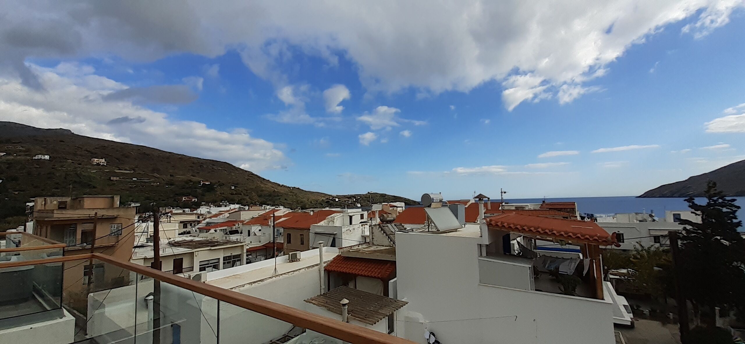 Et kystnært boligområde med bygninger, klar himmel og havudsigt.