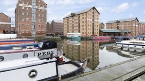 A waterfront with several brick warehouses and boats docked. - Elliot Oliver - Loft Style 2 Bedroom Apartment With Parking In The Docks (Gloucester)