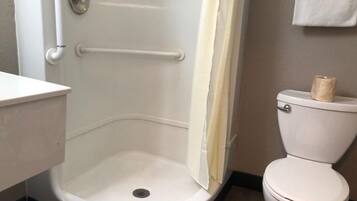 A bathroom with a white toilet, a shower with a white door, and a towel rack.