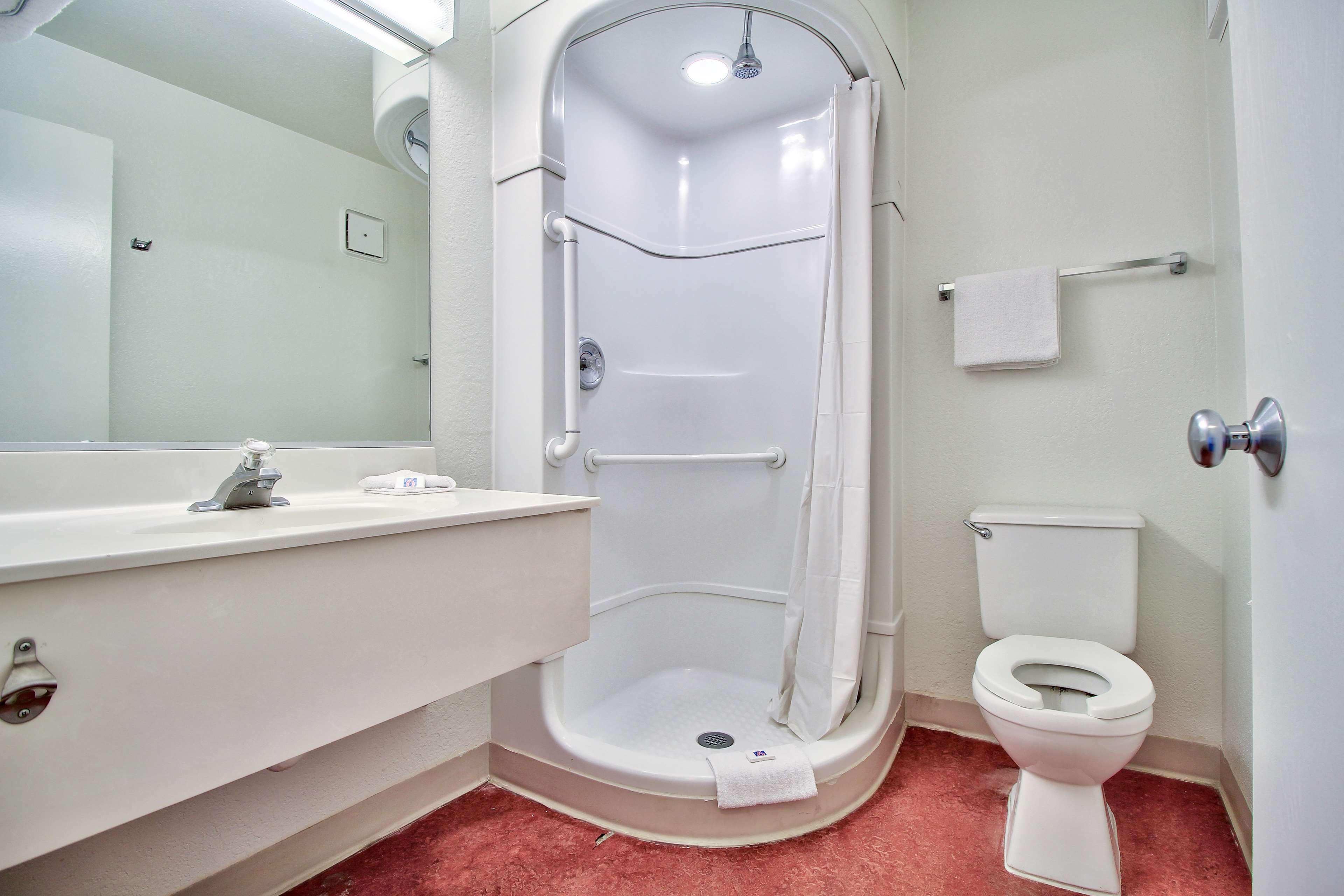 Une salle de bain avec une douche à l’italienne, des toilettes et un lavabo.