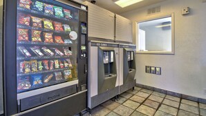 A vending machine with various snacks and a push-button ice cube dispenser.