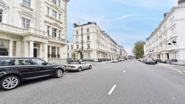 A street lined with classic white buildings, parked cars, and a clear sky. - Smart flat near Pimlico Tube (London)
