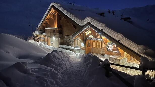 A wooden mountain lodge with a restaurant sign, surrounded by snow. - Skiing and après ski in pain and residence (Les menuires)