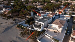 An aerial view of a residential area with modern houses, a sandy beach, and a clear sky. - ARES - Vue Mer - Accès direct plage (Agde)