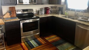 A modern kitchen with stainless steel appliances, a microwave, a stove, and a sink.
