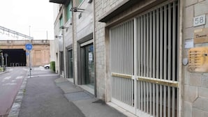 A street view with a closed metal gate, a bicycle lane, and a building with a sign reading "Dimora". - Soggiorno La Coccinella (Florence)