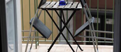 A balcony with a small table and two chairs.