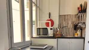 A compact kitchen with a microwave, sink, and utensils. - Soggiorno La Coccinella (Florence)