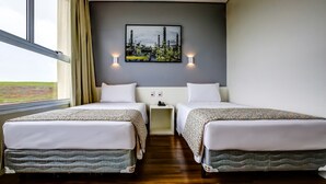 A hotel room with two beds, a nightstand, a painting, and a window with curtains. - Sleep Inn Paulinia (Paulinia)