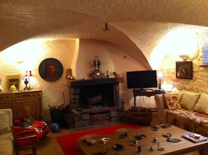 A cozy living room with a fireplace, a television, and a red car model.