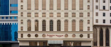 A multi-story building with a central entrance featuring a large sign reading "RAMADA EASTVALLEY."