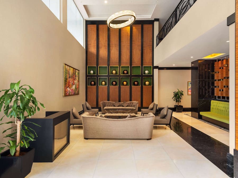 Un vestíbulo moderno con un sofá, una planta en maceta y una pared con paneles decorativos.