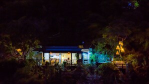 Una casa con cocina y comedor a la vista, rodeada de árboles.
