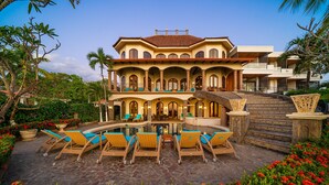 A large, multi-story building with a pool and outdoor seating area.