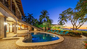 A pool area with lounge chairs and a stone pathway.