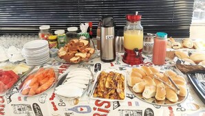Um buffet de café da manhã com diversos alimentos e bebidas.